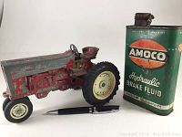 Toy tractor next to Amoco hydraulic brake fluid can and black pen for size reference