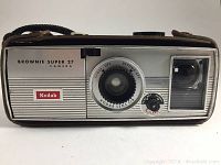 Front view of Kodak Brownie Super 27 camera showing lens, flash, and viewfinder with branding and focus markings.