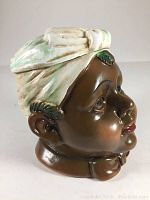 Front side angle of ceramic tobacco jar showing brown face, turban top lid and detailed features