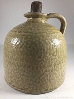 Front view of textured glaze jug with handle and wooden stopper