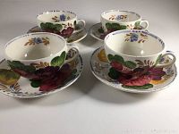 Four English tea cups and saucers with hand-painted Belle Fiore floral patterns by Simpsons Potters, showing overall set and details of design.