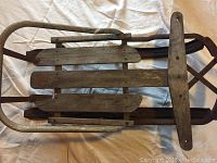 Top-down view of the wooden baby sled showing the seat slats and metal runners.