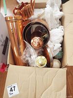 Box containing copper and ceramic kitchen items including canisters and salt and pepper shakers.