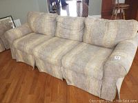 Front view of a 3-seater couch upholstered in patterned beige fabric with light yellow stripes.