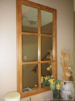 Front view of six pane wooden window mirror showing full mirror divided into six rectangular sections with light brown wooden frame.