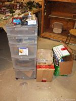 Plastic storage drawers, cardboard boxes and train items scattered on floor