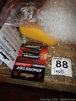 Energizer batteries with other items on a wooden surface.