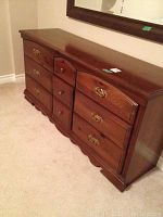 Front right angled view of dresser showing dark stained pine wood and drawer layout with metal handles.
