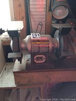 Front view of a Craftsman 6 inch bench grinder with grinding wheels and tool rests on both sides.