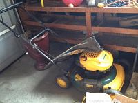 Full side view of Yardman 6.75 HP lawnmower with rear bagger and ceramic planter behind it.