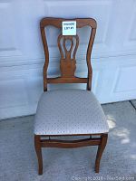Front view of a single Stakmore Chippendale folding side chair showing wooden frame, curved top rail, pierced back splat, and beige upholstered seat.