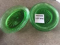 Top view of two green depression glass round dinner plates showing ribbed pattern and bright green color.