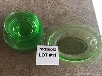 Green Depression glass oval serving dish and dessert plate on a carpeted surface with lot number card.