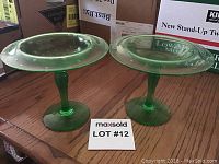 Two green Depression glass candy dishes with hobnail pattern sitting on wooden surface, both without chips or cracks.