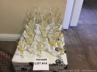 20 light amber glasses grouped by size on white box, no chips visible.