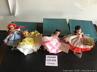 Four 8-inch Madam Alexander Little Women dolls arranged side by side, each in distinct period costume with tags.