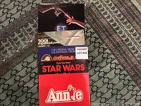 Four soundtrack vinyl LP album covers stacked face-up on carpet: E.T., 2001: A Space Odyssey, Star Wars, Annie.