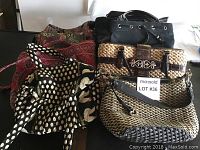 Seven assorted handbags including Brighton, Vera Bradley, and Coach brands arranged on table