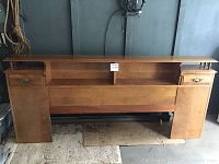 Full view of the vintage maple king size headboard showing its wide rectangular shape, two drawer compartments on each side, and an open shelf in the center.