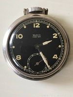 Close-up image of the 1950's Westclox Pocket Ben pocket watch showing black face with cream numerals and silver-tone casing, with visible winding crown and secondary seconds dial.