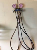 Full view of JB Industries manifold with red, yellow, and blue hoses attached, showing gauge and valves to confirm item identity and condition.