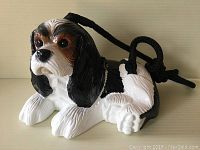 Front view of hand-painted beagle shaped purse with black cord strap.