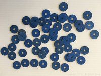 Several blue World War II Canada meat ration tokens arranged on a light surface, showing quantity and overall condition.