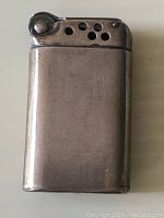 Front view of the vintage sterling silver lighter showing a smooth surface and engraved lines.