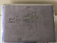 Front of cigarette case showing embossed map of Dominion of Canada with 'Jack 8338-E' marking.