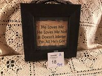 Front view of the wooden sign on beige crochet fabric background showing black frame and text