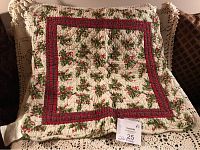 Front view of the small square Christmas quilt showing holly and red plaid border pattern.