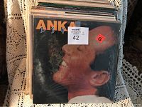 Stack of vinyl albums with a visible album titled 'Anka Live' featuring a side profile photo of a man smiling.