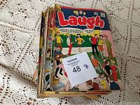 Stack of Archie Series and Laugh comic books showing colorful covers with multiple characters, some wear visible on edges and corners.