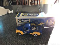 Front angle photo of the die cast metal bank model and its original box showing branding and labeling