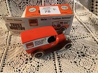 Die cast model of 1916 Studebaker panel delivery bank with original box in background, showing orange and brown colors and white signage.