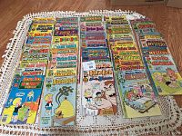 Photo showing an overhead view of a large stack of Richie Rich comic books arranged in rows with varied cover titles and conditions from heavily worn to better preserved.