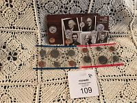 Two uncirculated coin sets with P and D mint marks displayed on lace cloth, including various US coins and informational card featuring US presidents' images.