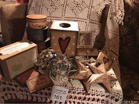 Photo of assorted country crafts including tissue box holder, three-tier boxes, cookie cutters, magnets, wooden plaques.