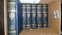 Seven volumes of Peoples of All Nations, showing top spines and front cover edges in a cardboard box.