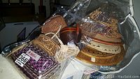 Woven baskets and hats grouped together displaying variety in size and weave patterns.