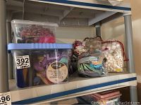 Photo showing two stacking shelves with various clear containers and bags filled with ribbons, Styrofoam balls, plastic clips, and other assorted crafting materials.