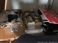 Three boxes of crafting ribbons and lace trims arranged, with one box having lace, another plastic box with ribbon rolls, and a cardboard box with ribbons.