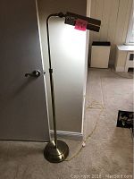Full view of a brass style floor lamp standing approximately 43 inches tall with a long yellow cord and cylindrical shade.