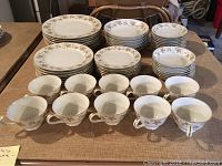 Photo showing full set of china including plates, cups, and saucers arranged neatly on a table