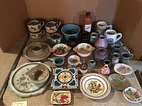 Overview photo showing the entire assortment of pottery items including soup cups, bowls, mugs, plates, trivet tile and covered sugar dish.