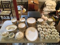 Full view of the china set including plates, cups, saucers, bowls, and serving pieces arranged on table.