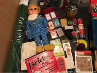Photo showing Mrs. Beasley doll, Bicycle playing cards, Bridge tally cards, marbles in cup, and various card game accessories.