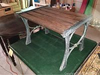 Cast iron bench with oak slats from an angled side view showing overall structure and condition.