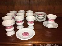 Full set of 11 custard cups and 11 matching underplates, total 22 pieces, on wooden surface.