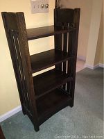 Front angle showing three shelves and dark wood finish of the Mission style oak bookcase.
